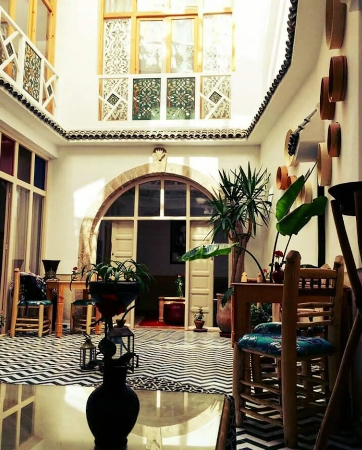 The main patio of the riad under its stone arch, in golden light