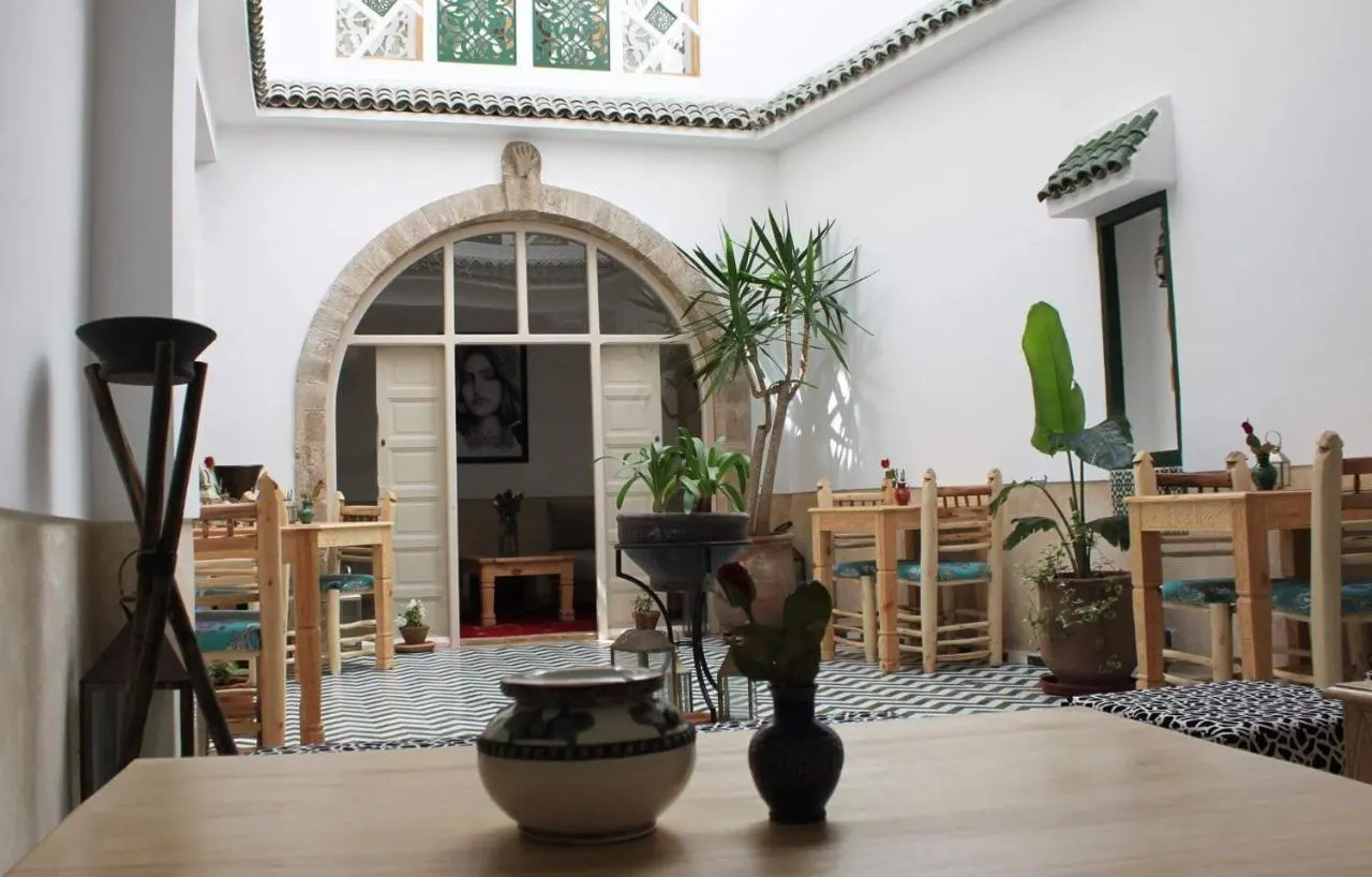 The main patio: whitewashed walls, stone arch and green fretwork screens